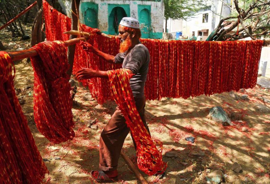 TO DYE FOR: A worker hangs kalavas or sacred threads to dry after dyeing them with colours in Ajmer, Reuters/UNI