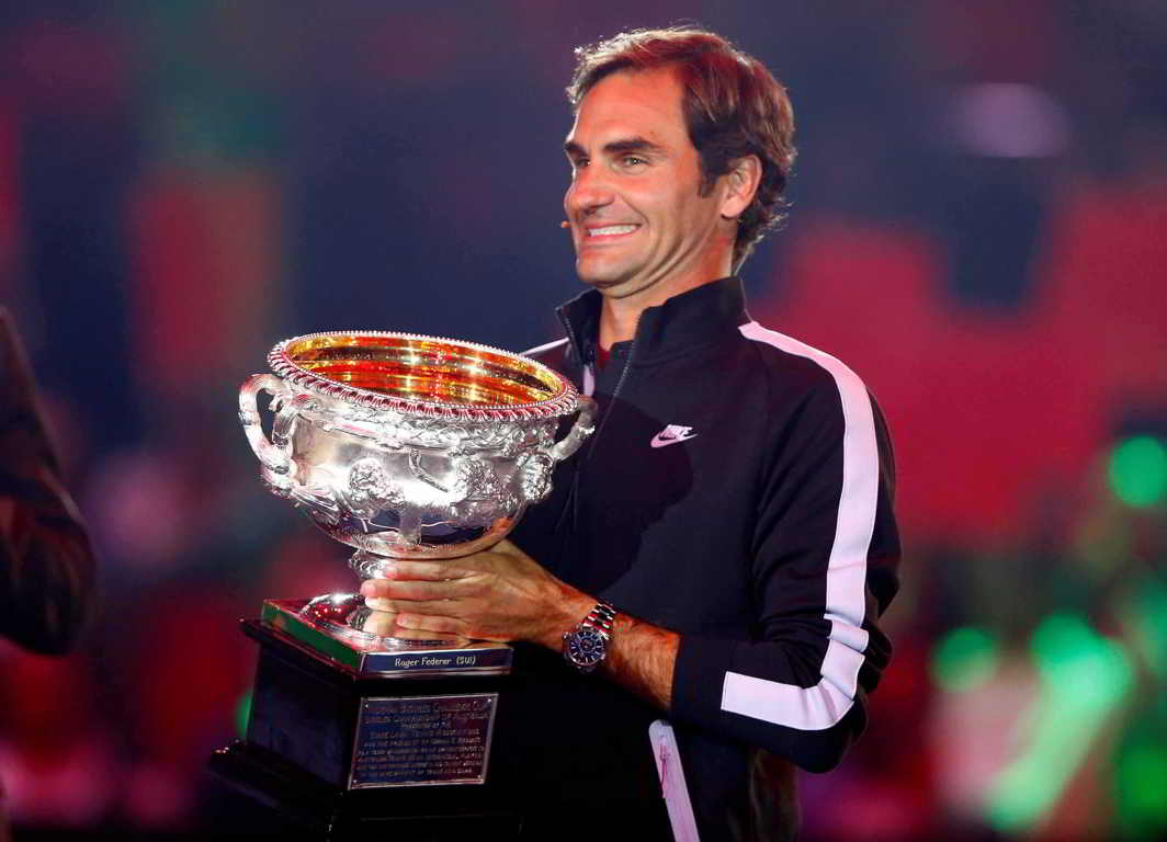 CUP THAT CHEERS: Switzerland's Roger Federer displays his Australian Open trophy before taking on Andy in a charity match in Zurich. Federer won 6-3 7-6 (7-5), Reuters/UNI