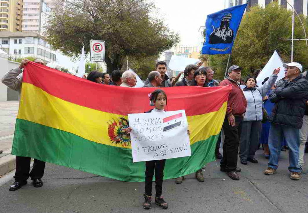 POINT OF VIEW : A girl holds a sign that reads "We are Syria, Trump killer" during a protest against the US military strike against Syria, in front of the US Embassy in La Paz, Bolivia, Reuters/UNI