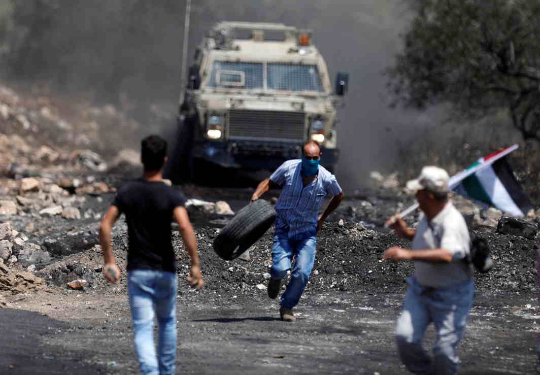 COME ON: Palestinian protesters run in front of Israeli troops during clashes in the West Bank village of Kofr Qadom near Nablus, Reuters/UNI