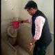 Education Minister Praful Panseria cleans school's dirty toilet