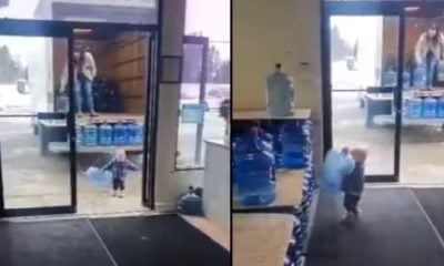 Little boy helps mother unload water jars