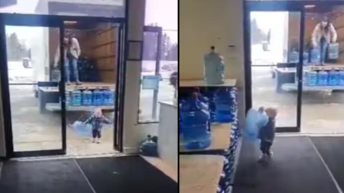 Little boy helps mother unload water jars