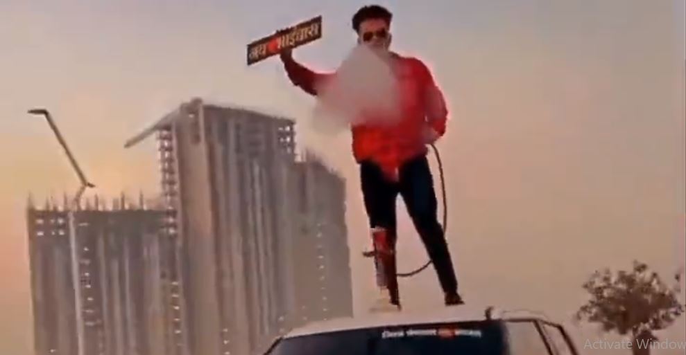 man standing atop car, smoking hookah