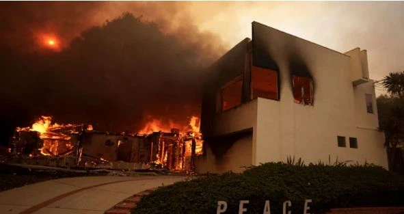 Wildfire burning in Los Angeles, California, with smoke and flames spreading across the Pacific Palisades area.