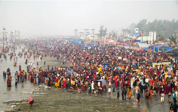 Devotees gathered at a riverbank taking a holy dip during Makar Sankranti celebrations