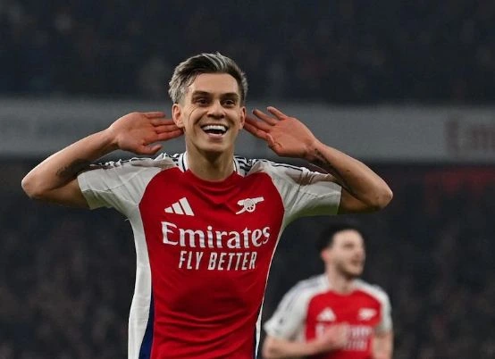 Arsenal players in a jubilant celebration following their goal against Tottenham in a critical match.