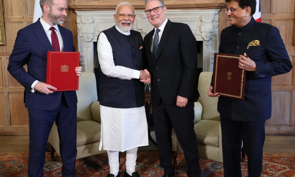 Image shows Narendra Modi and Keir Starmer with Piyush Goyal and Jonathan Reynolds.