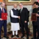 Image shows Narendra Modi and Keir Starmer with Piyush Goyal and Jonathan Reynolds.